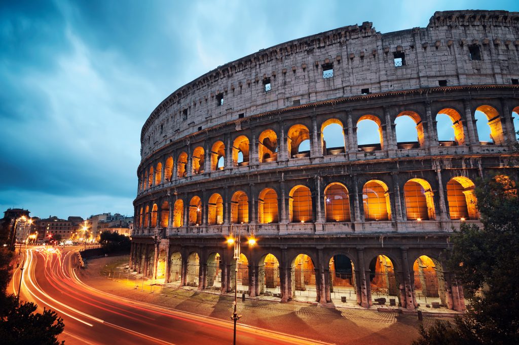 Lighting up a Parodi Cigar at the Coliseum at night with colorful blurred traffic lights.